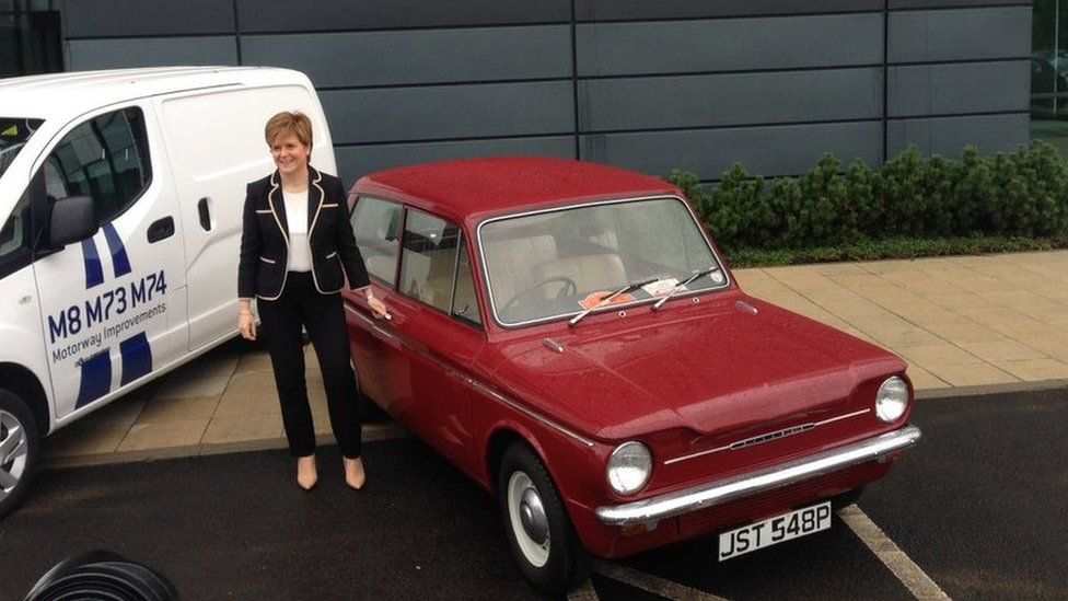 Nicola Sturgeon standing beside a vintage car
