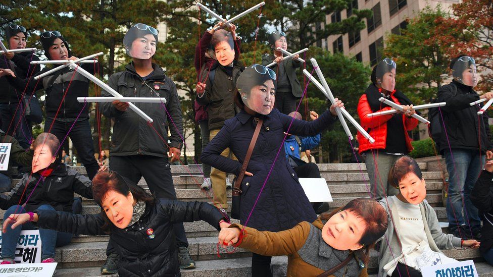 Protesters wearing masks of South Korean President Park Geun-hye (bottom) and her confidante Choi Soon-sil (top) in central Seoul, 29 October 2016