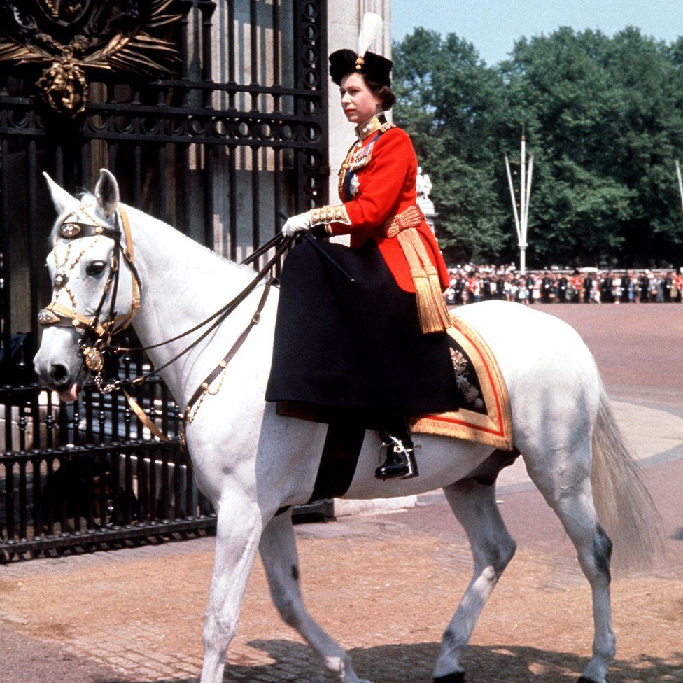 Riding side-saddle, the Queen returns to Buckingham Palace