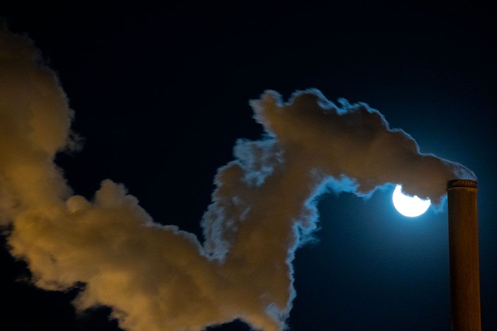 Steam from an industrial chimney is illuminated by reflected light from the supermoon at the Leathers Geothermal Facility near Calipatria, California, US