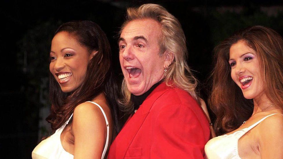 February 28 2000 showing nightclub owner Peter Stringfellow launching his new range of underwear with the help of two models.