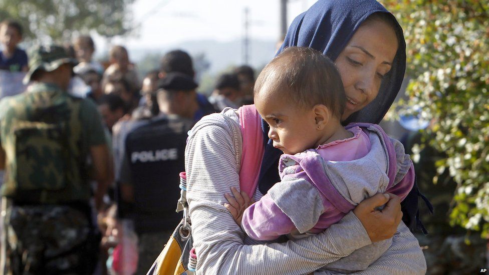 A woman migrant with a baby enters into Macedonia from Greece