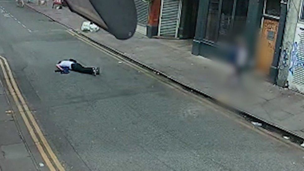CCTV of victim of an assault lying unconscious in the road