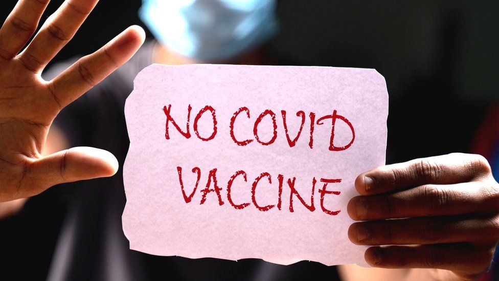 Piece of paper says "No Covid Vaccine"