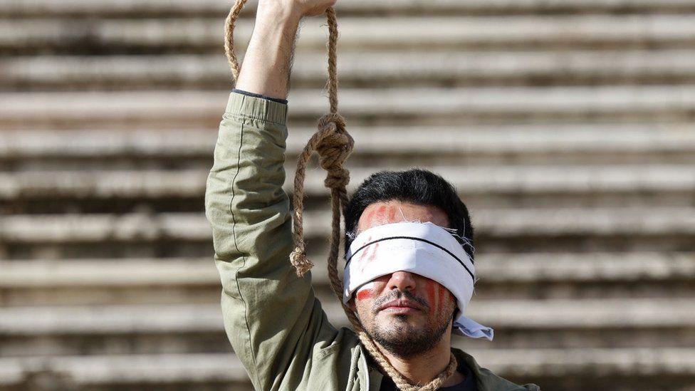 Ирано-португальский мужчина протестует против казни двух иранцев в связи с антиправительственными протестами в Иране, в Лиссабоне, Португалия (16 декабря 2022 г.)