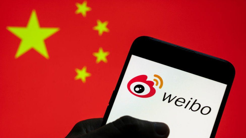 Chinese social media platform Weibo logo seen on an Android mobile device with People's Republic of China flag in the background.