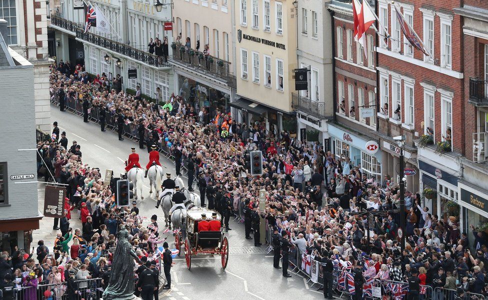 Crowds cheer Jack Brooksbank and Princess Eugenie as they embark on a carriage ride following their wedding at Windsor Castle