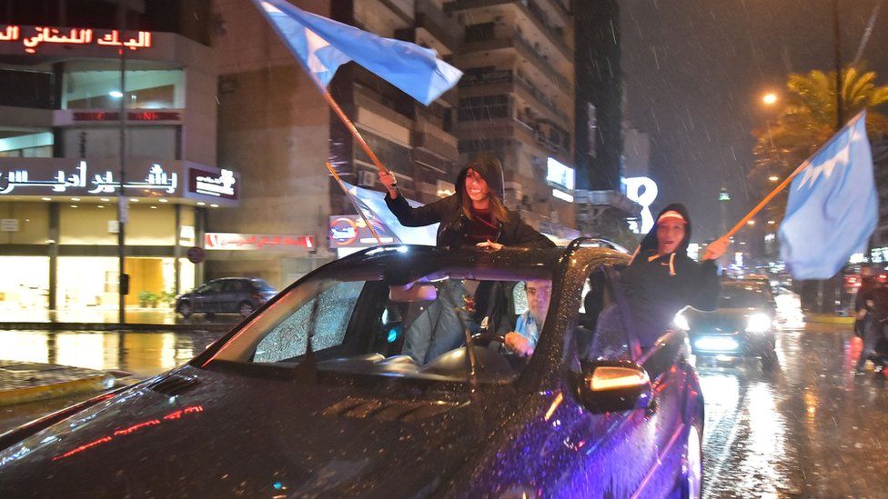 Supporters of Saad Hariri wave Future Movement flags as they celebrate in Beirut on 21 November 2017
