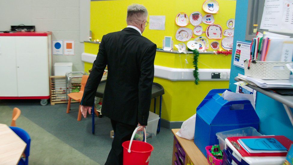 At Russell Scott Primary in Denton, Greater Manchester, head teacher Steve Marsland empties out buckets of water collected from leaks around the school