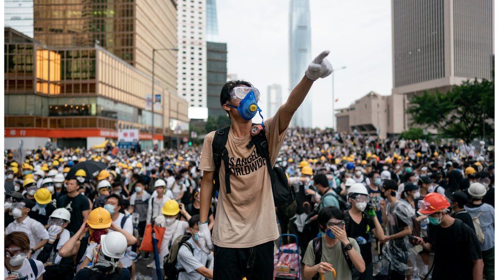 A man in a gas mask points during a 2019 protest in Hong Kong