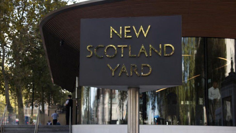 Exterior of New Scotland Yard, with revolving sign in the foreground