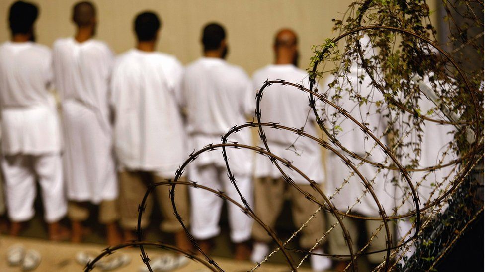 Detainees stand during an early morning Islamic prayer at the U.S. military prison for 'enemy combatants' on October 28, 2009 in Guantanamo Bay, Cuba.