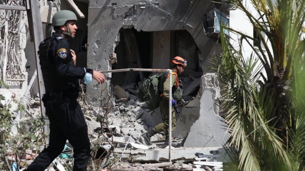 Силы безопасности Израиля осматривают дом в городе Ашкелон, который был поражен ракетой, выпущенной из сектора Газа (11 мая 2021 г.)