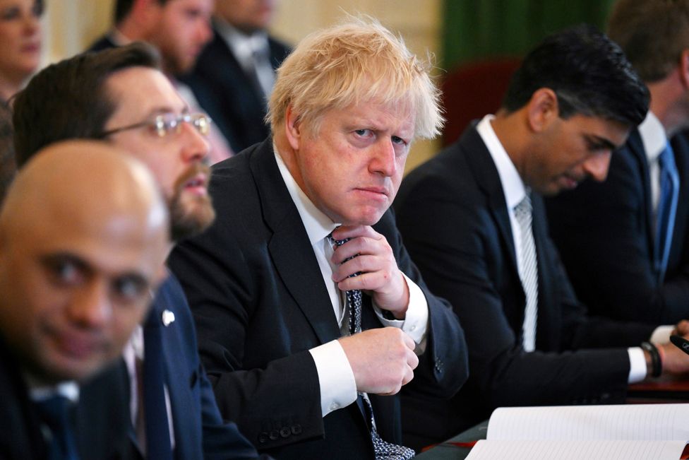 Prime Minister Boris Johnson adjusts his tie at the start of a cabinet meeting at 10 Downing Street in London, on 24 May 2022