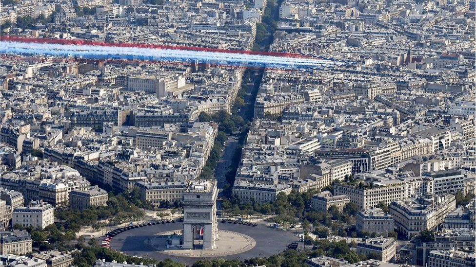 Alpha Jets overflying the capital with plumes of smoke in the colours of the French flag