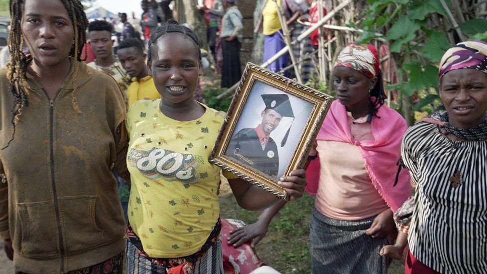 People holding up a photo of one of those who died in a landslide in Gofa, Ethiopia - 24 July 2024