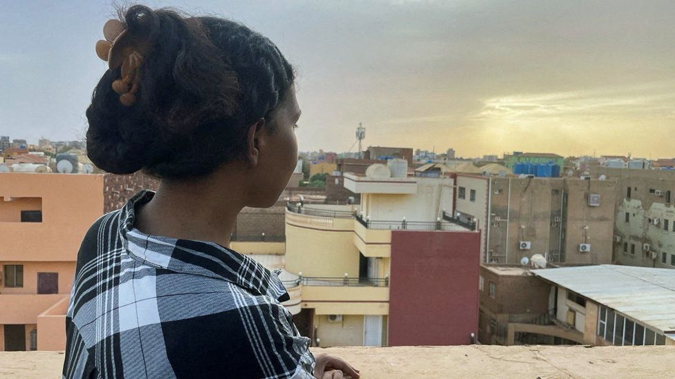 A woman looks at the city from the rooftop of her house during the conflict in Khartoum, Sudan - 30 April 2023