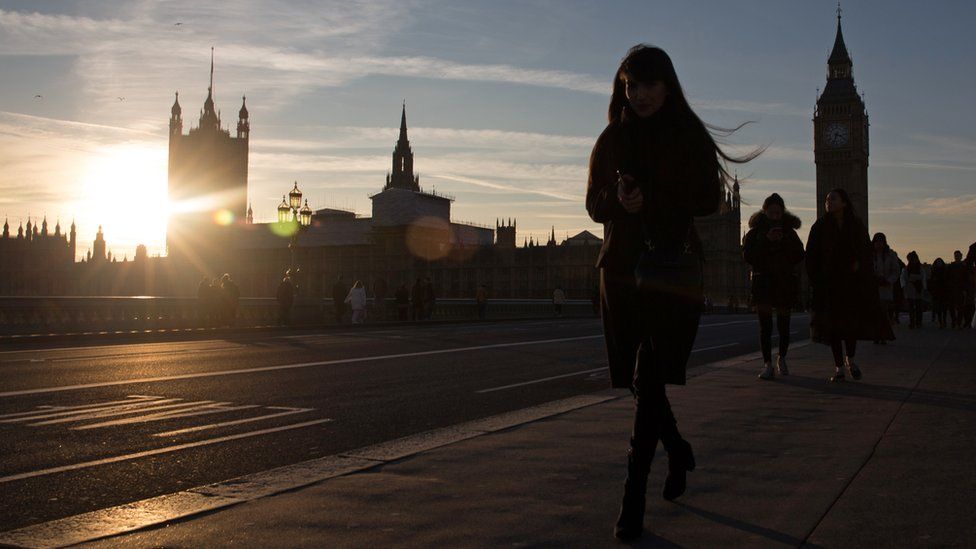 A woman walks across Westminster Bridge