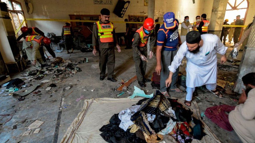 Rescue workers collect remains after a blast at a religious school in Peshawar on October 27, 2020