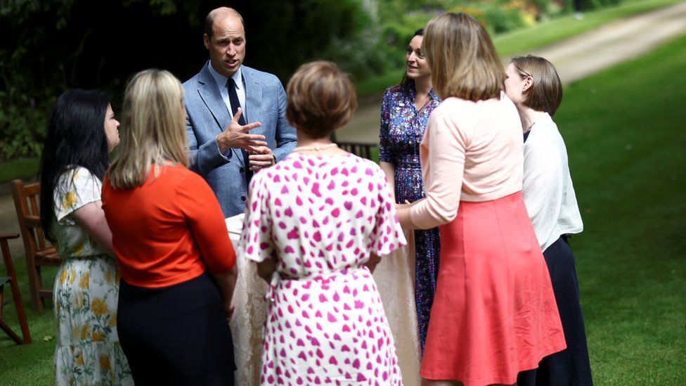 The Duke of Cambridge speaks to NHS workers in the gardens at Buckingham Palace