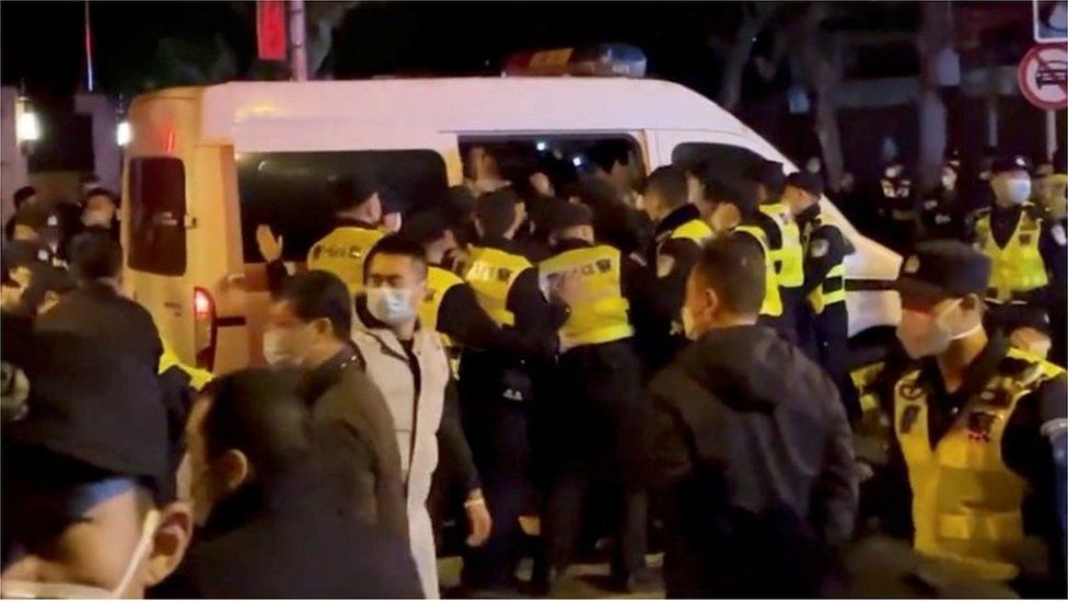 Полицейские задерживают людей во время акции протеста против коронавирусной болезни (COVID-19) у бордюров на месте зажжения свечей в память жертв пожара в Урумчи в Шанхае, Китай, на этом снимке экрана, полученном из видео, выпущенного 27 ноября 2022 года. || |
