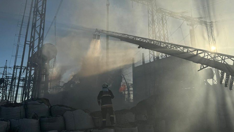 Smoke rising and firefighters work at a damaged power plant