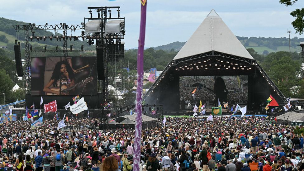 View of the Pyrmid Stage and crowd with Olivia Dean on stage and on a big screen