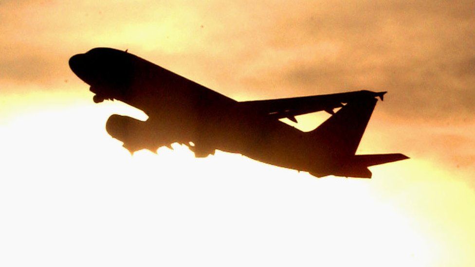 A plane is silhouetted against the sky as it takes off from Heathrow Airport December 19, 2002 in London, England.