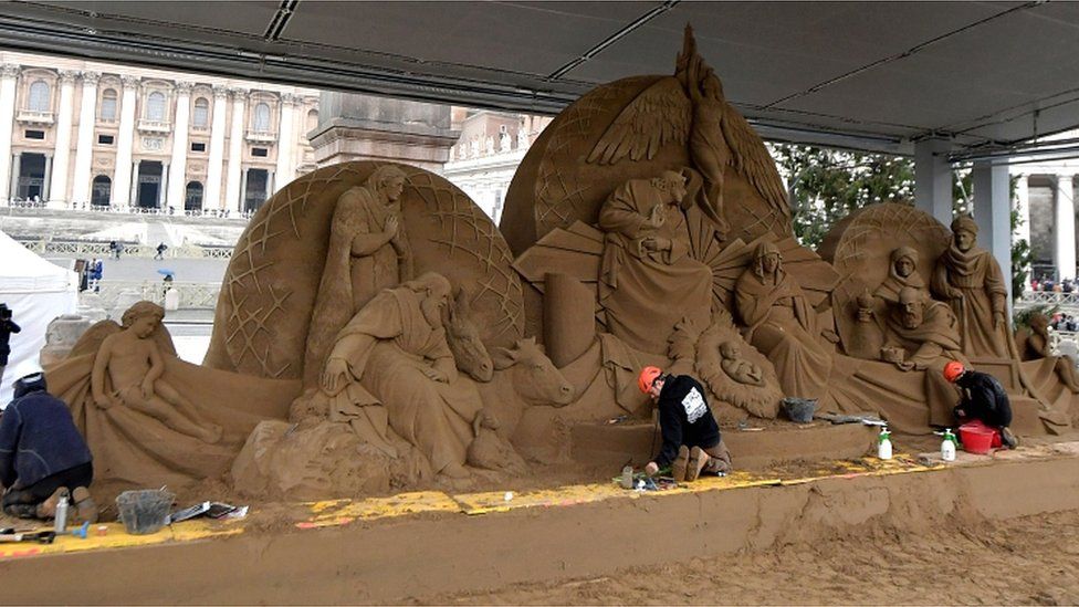 Russian artist Ilya Filimontsev (L) and Czech artist Radovan Zivny (R) sculpt sand to construct a nativity scene at Piazza San Pietro in The Vatican on 6 December 2018