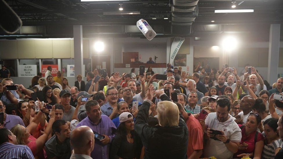 US President Donald Trump throws a paper towel roll as he visits the Cavalry Chapel in Guaynabo, Puerto Rico