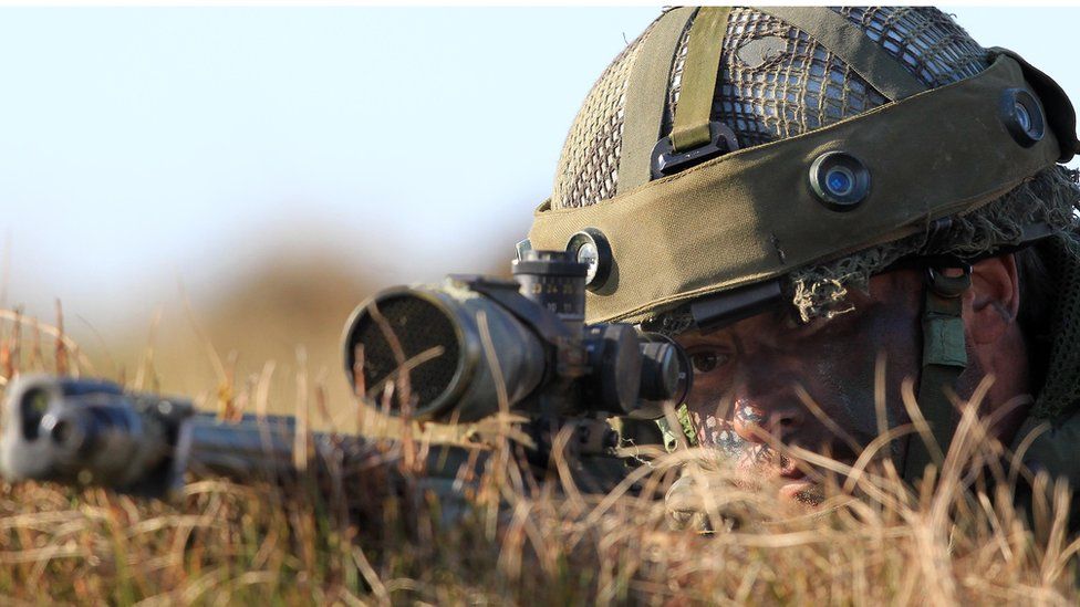 A British military sniper from the looks though his scope during the 16 Air Assault Brigade Exercise Joint Warrior at West Freugh Airfield.