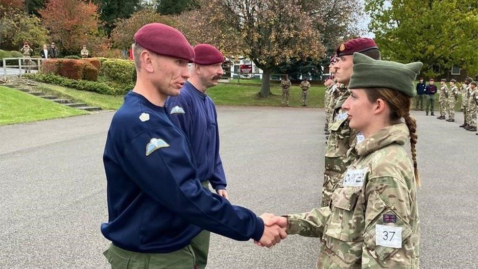 Pte Addy Carter being presented with her maroon beret by Major Chris Braithwaithe on passing P Company