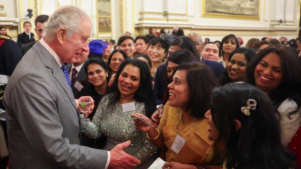 Britain's King Charles speaks with guests as he meets nurses and midwives to celebrate their work, at Buckingham Palace, in London