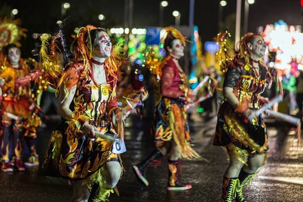 Women dance outside in carnival outfits at Taunton Carnival.