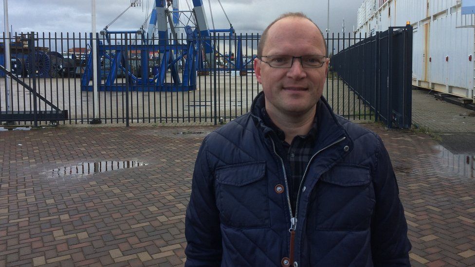 Peter Westdijk in front of cranes at the port of Rotterdam