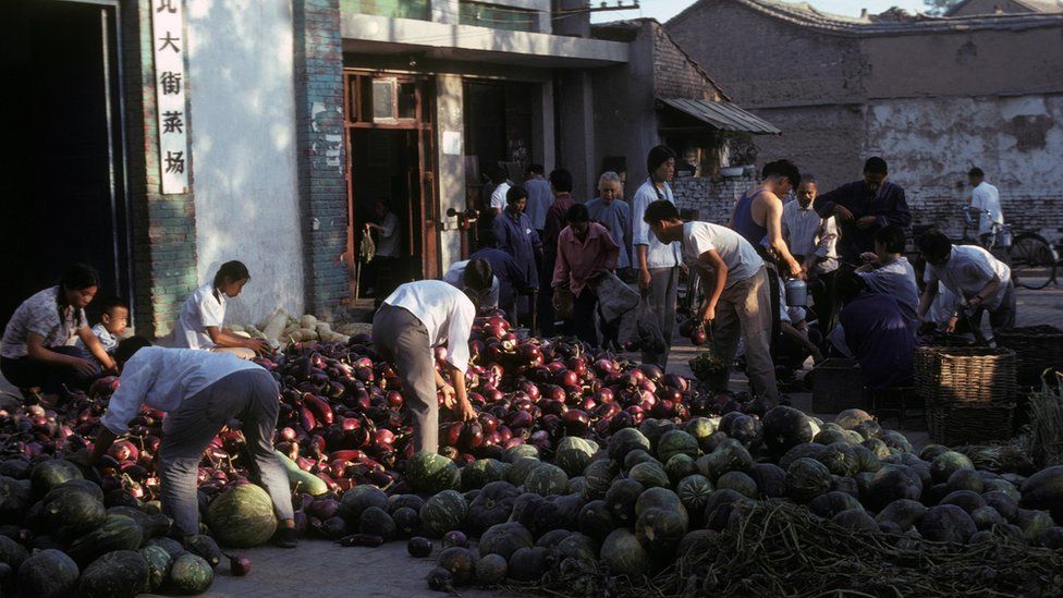 Melons and aubergines on the ground in a market in Xi'an, China, August 1978