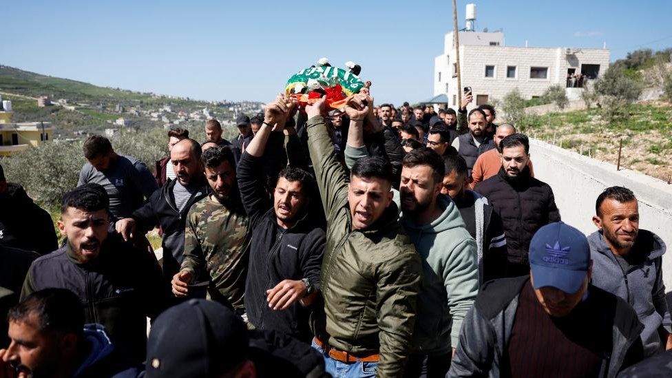 Mourners carry the body of 11-year-old Palestinian Amr Al-Najjar who was killed in an Israeli raid, during his funeral near Nablus, in the Israeli-occupied West Bank, 5 March 2024