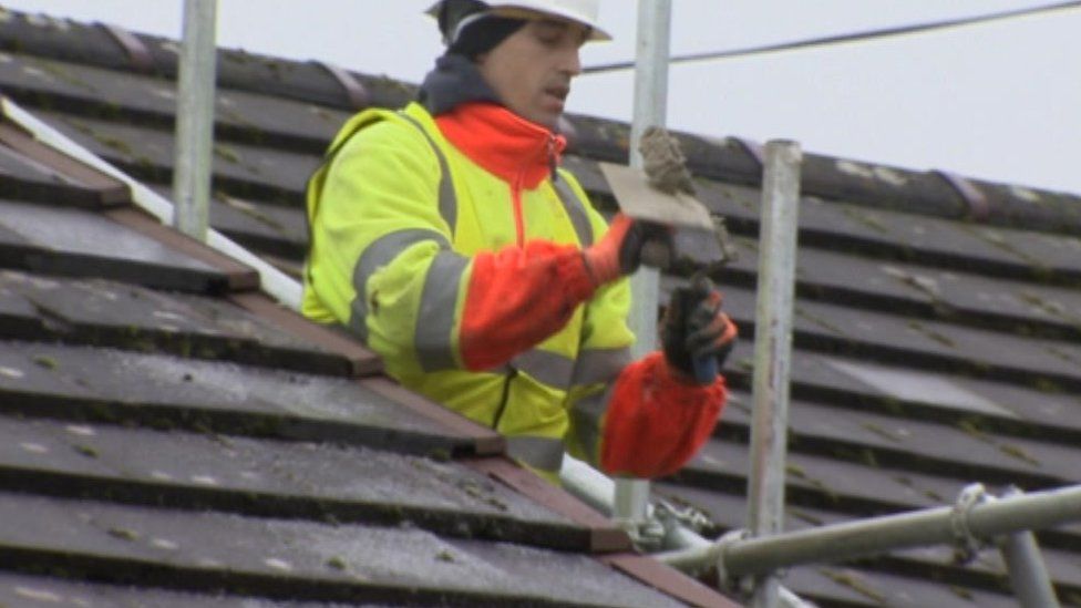 Workman on roof fitting insulation