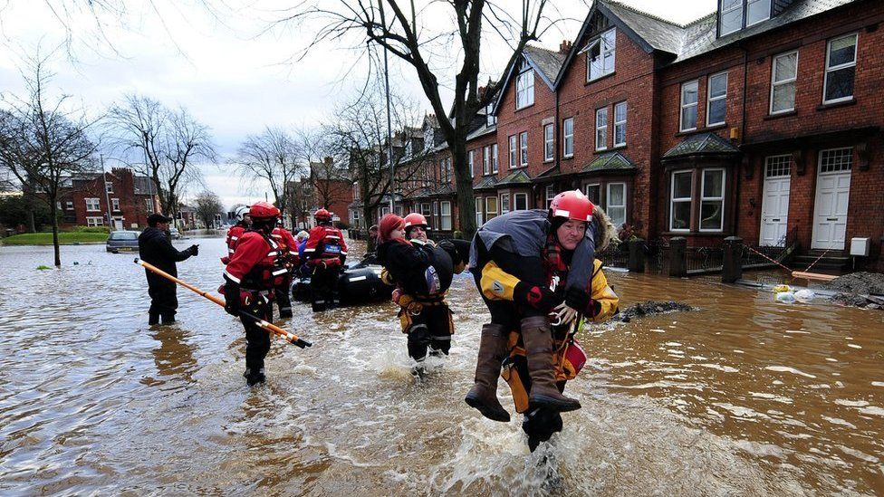 Rescue teams carry people out of flooded homes in Carlisle on Monday morning