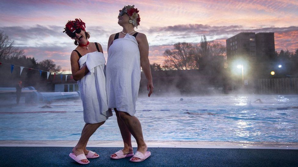 Jessica Walker and Nicola Foster posing by the pool during sunrise before swimming at Charlton Lido in Hornfair Park, London, on its first day of reopening after the second national lockdown ended.