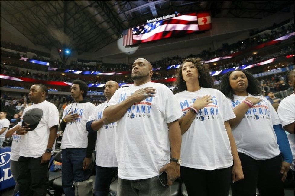 U.S. service personnel stand during the playing of the national anthem before an NBA basketball game between the Denver Nuggets and Dallas Mavericks on Monday, Dec. 12, 2016, in Dallas.