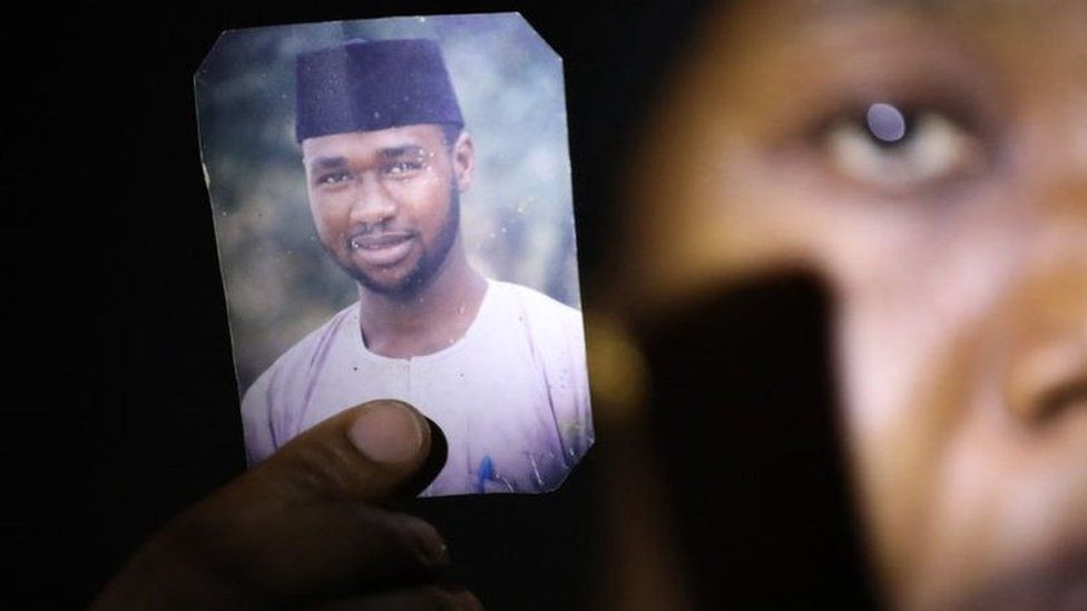 Amina Ahmed, wife of Mubarak Bala, an outspoken atheist who was charged with blasphemy, displays her husband's photo at their home in Abuja, Nigeria, on March 11, 2021.