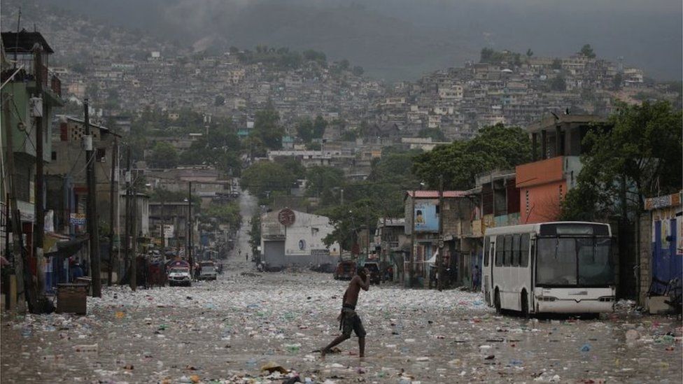 A man walks in a flooded street during the passage of Tropical Storm Laura, in Port-au-Prince, Haiti August 23, 2020.