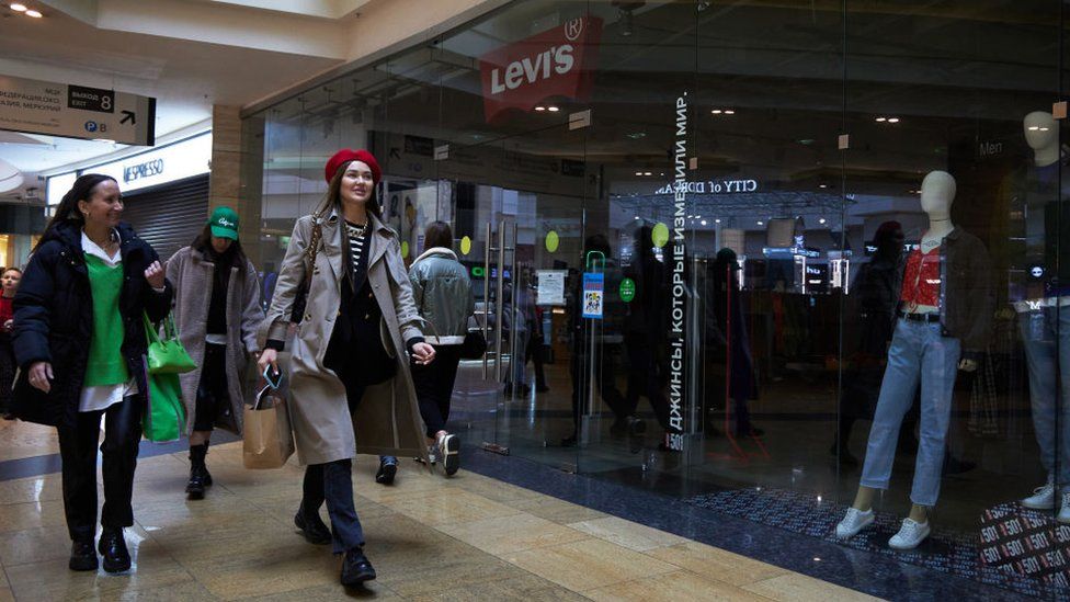 Shoppers walk by a shuttered Levi's store in Moscow