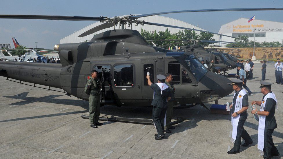 A Philippine Air Force chaplain blesses a Bell 412 helicopter during a 2015 christening ceremony