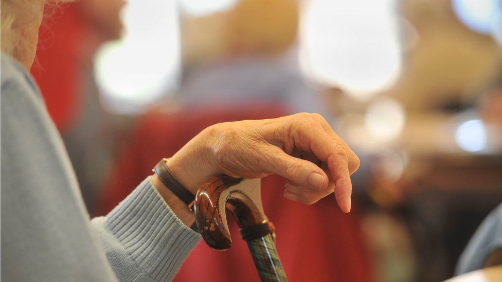 Stock image of an elderly lady with a walking cane