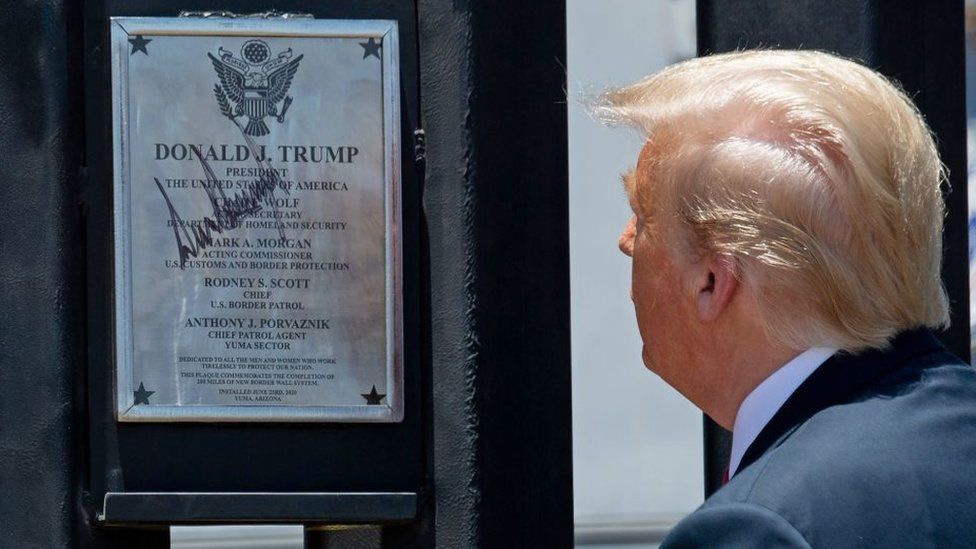 President Trump inspects a section of wall with a signed plaque on it