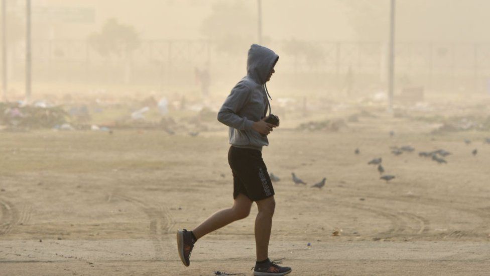 13 ноября 2021 года в Нойде, Индия, человек бегает трусцой рядом с землей, несмотря на то, что AQI находится в диапазоне от очень низкого до опасного.