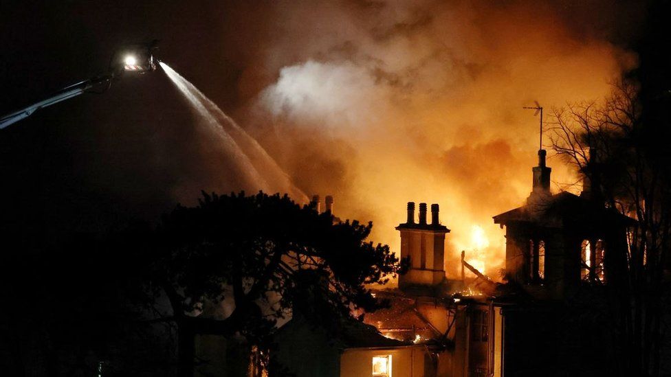 Firefighters using an aerial ladder platform to douse the flames at The Coppice in Torquay