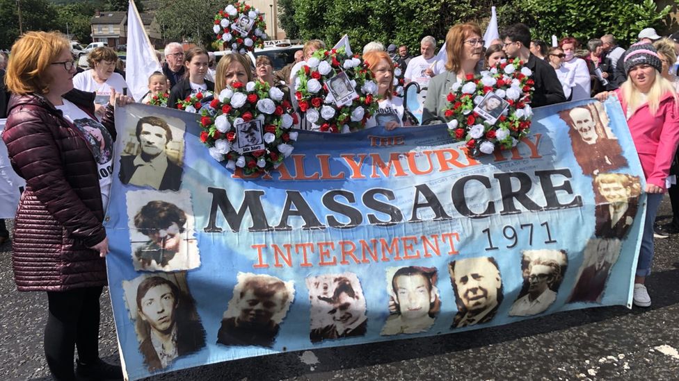 Families of those killed in Ballymurphy in 1971 holding a banner which reads 'Ballymurphy massacre' and has pictures of those killed